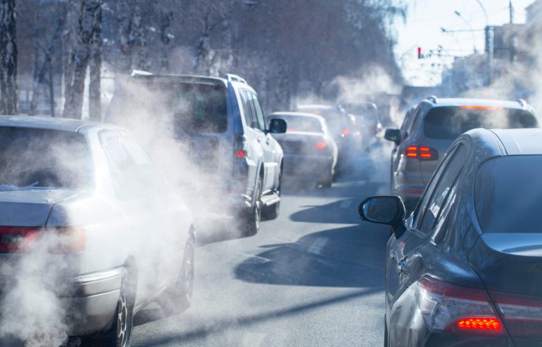 pollution from the exhaust of cars in the city in the winter. Smoke from cars on a cold winter day